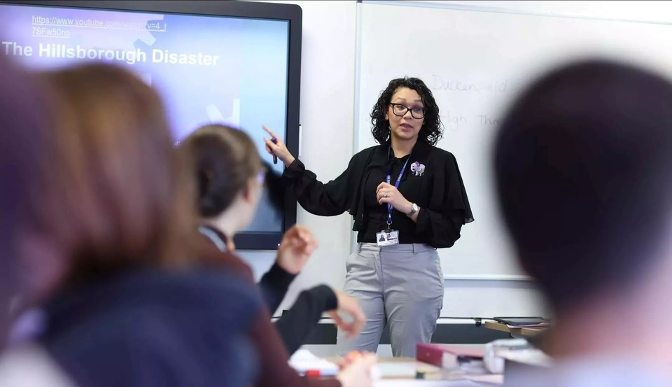 Staff member teaching in front of a screen