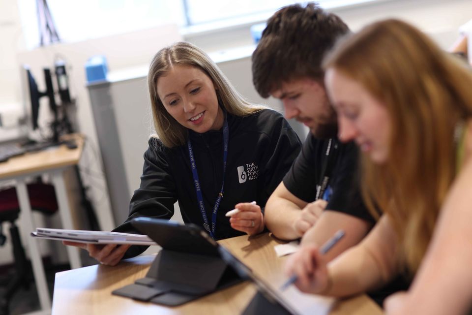 Image of teacher with two students using an iPad